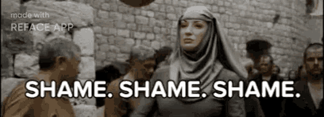 a woman in a hijab is standing in front of a crowd of people and says `` shame shame shame . ''