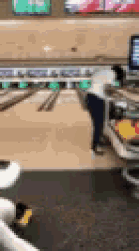 a blurry picture of a person bowling at a bowling alley