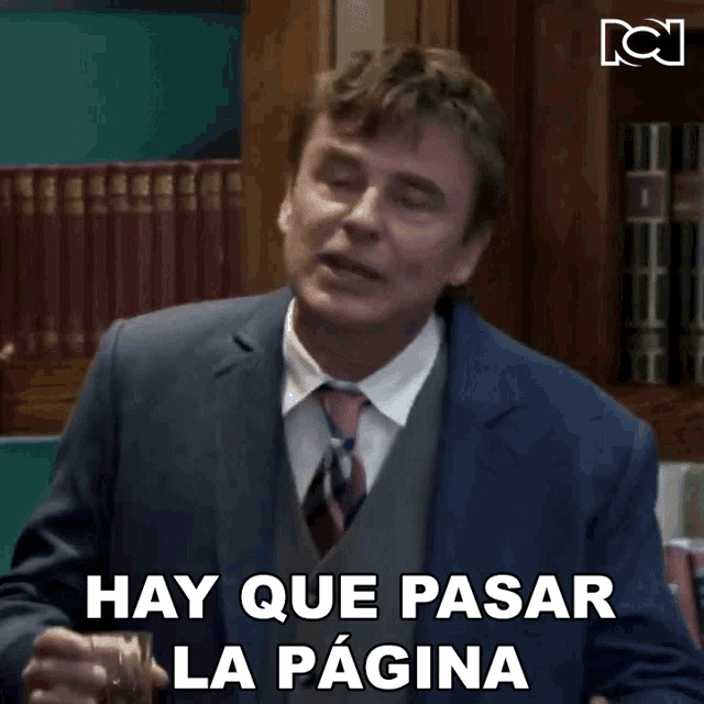 a man in a suit and tie is holding a glass of whiskey and says hay que pasar la pagina
