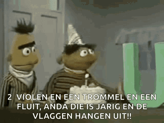 bert and ernie from sesame street are standing next to a birthday cake with a candle .