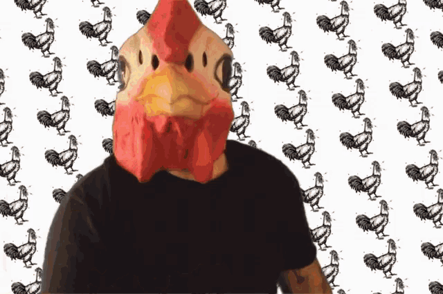 a man wearing a chicken mask stands in front of a rooster pattern