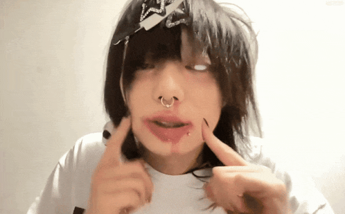 a person with a piercing in their nose is making a funny face