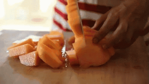 a person is cutting fruit on a cutting board