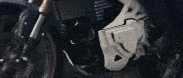 a close up of a motorcycle with a white fender and a black engine
