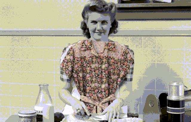 a woman in a floral shirt is standing in front of a bottle of lee