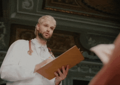 a man in a lab coat is holding a clipboard and writing on it