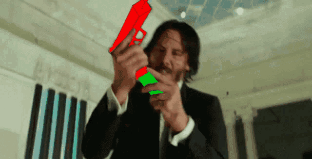 a man in a suit is holding a red and green gun