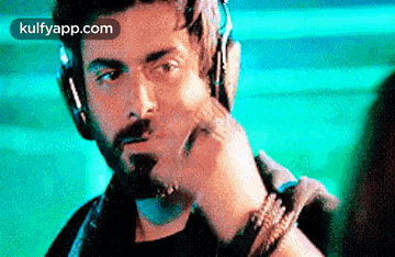 a man with a beard wearing headphones and a watch .