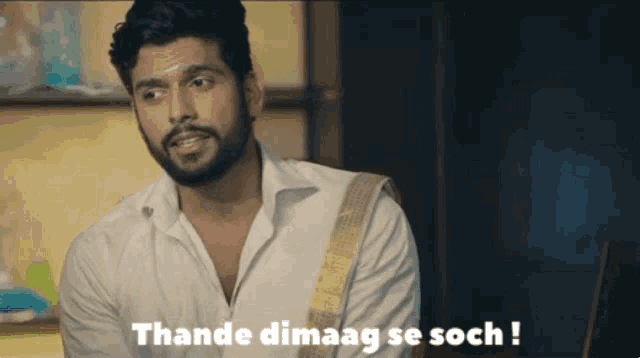 a man with a beard is wearing a white shirt and says thande dimaag se soch