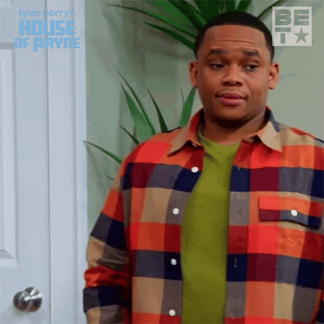 a man in a plaid shirt is standing in front of a door with the word house of payne written on it