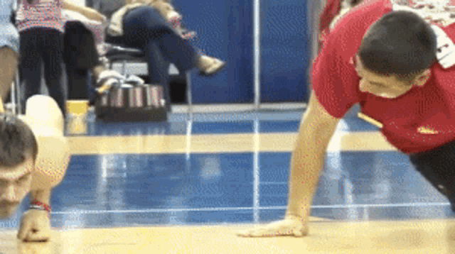 a man is doing push ups on a basketball court