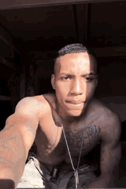 a shirtless man with a tattoo on his chest is taking a picture of himself