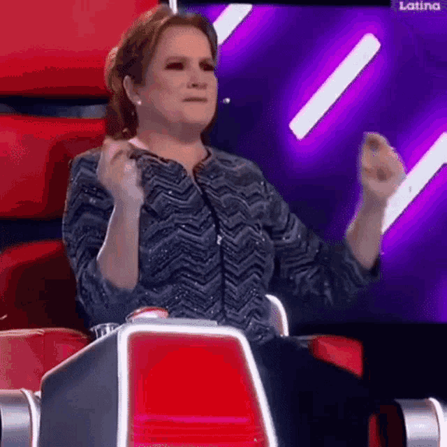 a woman is sitting in a chair with her arms in the air .