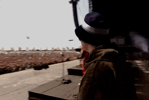 a man in a hat is looking out a window at a crowd