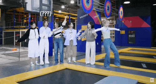 a group of girls are standing on a trampoline with a sign that says vikings in the background