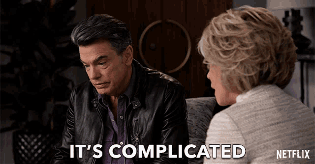 a man and a woman are sitting on a couch and the words it 's complicated are displayed