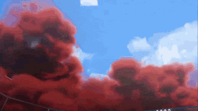 red smoke is coming out of a building in the sky