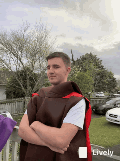 a man in a red cape is standing in front of a fence with a lively sticker on it