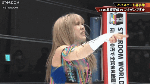 a woman in a wrestling ring with a sign that says stardom world on it