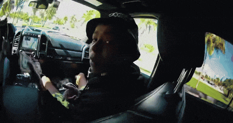 a man wearing a hat with the letter o on it is sitting in a car