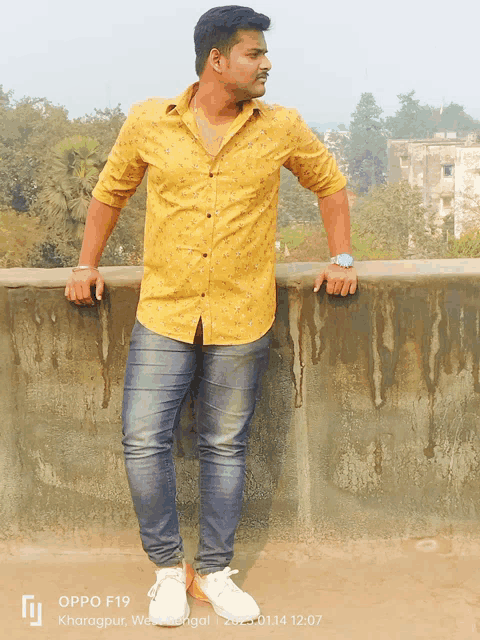 a man leaning against a wall with an oppo f19 photo taken on january 14th