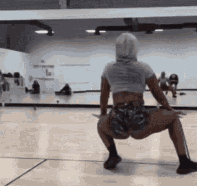a woman is doing a squat in a gym .