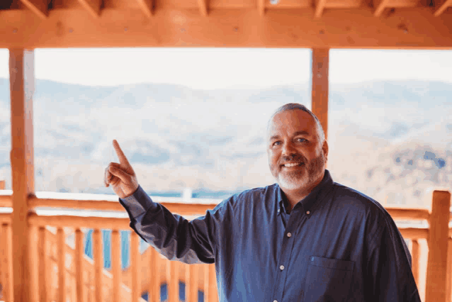 a man standing on a porch pointing upwards
