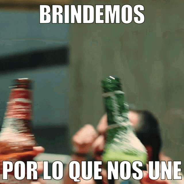 a blurred image of a person holding a bottle with brindemos por lo que nos une