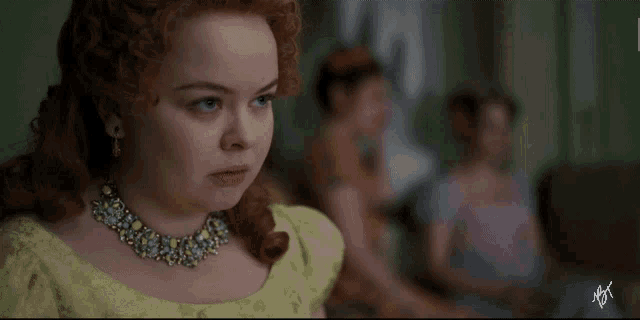 a woman with red hair wearing a yellow dress and a necklace with a watermark that says nft