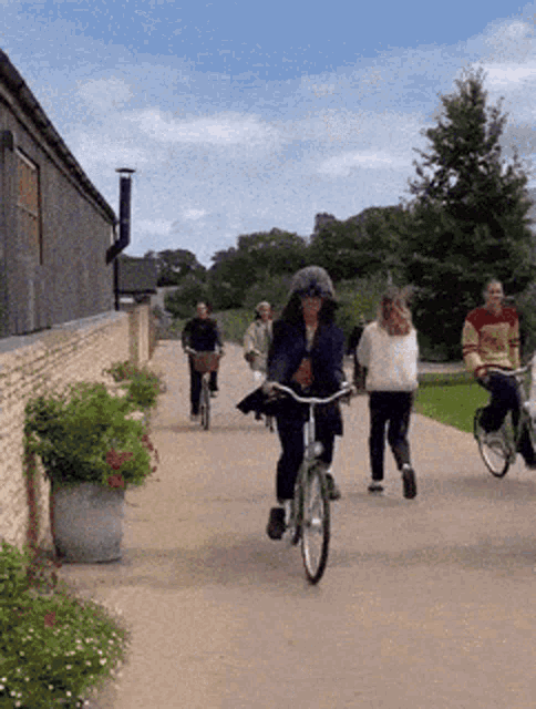 a group of people are riding bicycles down a street