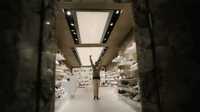 a person in a store with their arms in the air