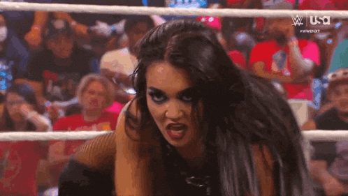 a woman in a wrestling ring is making a funny face .