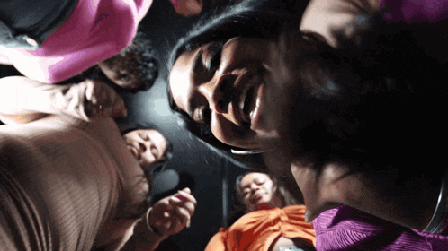 a group of women are sitting in a circle looking down at the camera