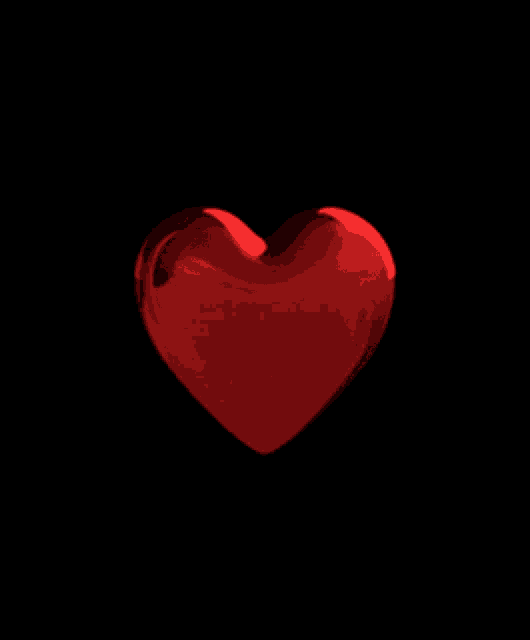a red heart with a black background is spinning