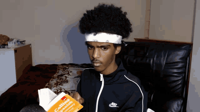 a man in a nike jacket is reading a book
