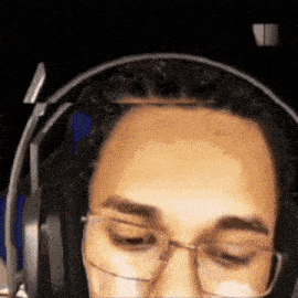 a man wearing headphones and glasses looks at the camera