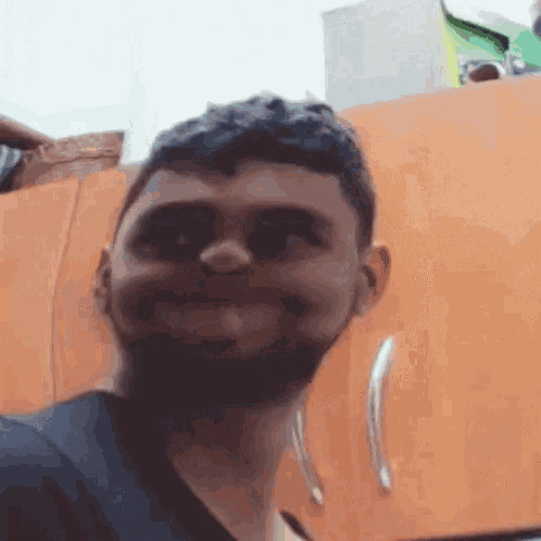 a man with a beard is making a funny face while standing in front of a cabinet .