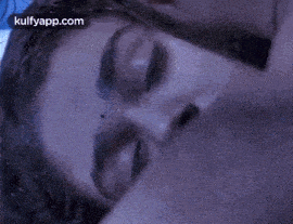 a close up of a man and woman kissing in the water .