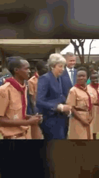 a woman in a blue suit is shaking hands with a man in a suit