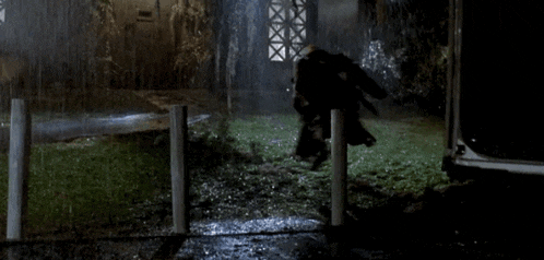 a person is standing in front of a house in the rain .