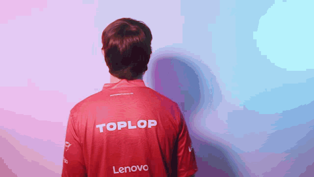 a man is wearing a red toplop shirt with lenovo on the back