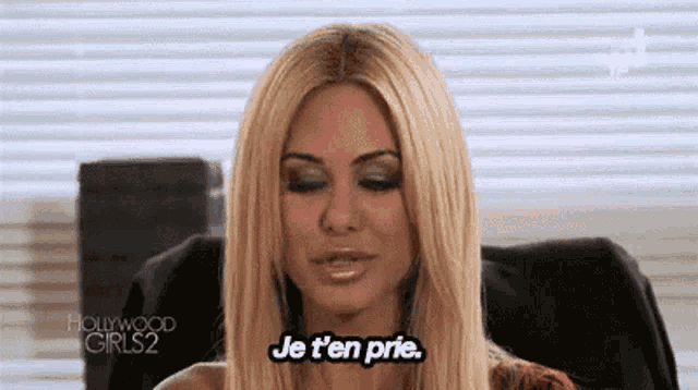 a woman is sitting in a chair with her eyes closed and says je t 'en prie .