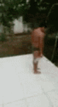 a man without a shirt is standing on a white tile floor .