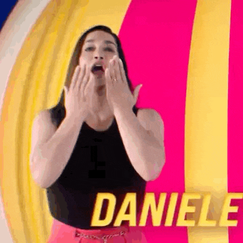 a woman is covering her mouth with her hands in front of a colorful background and the name daniele is on the bottom .