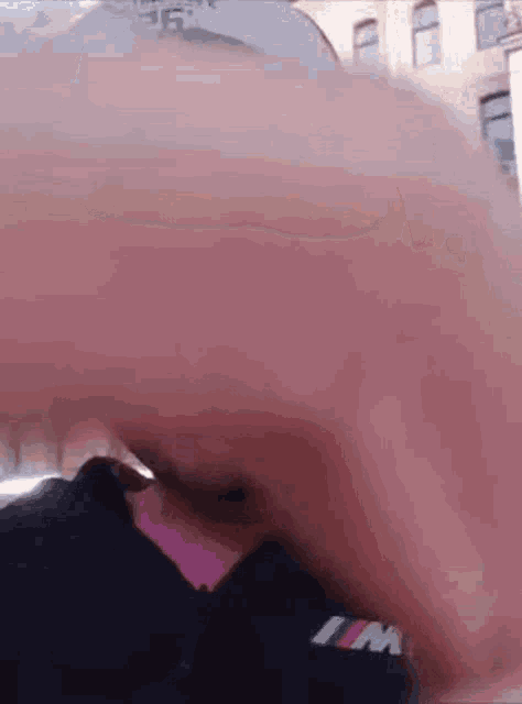 a close up of a person 's face with a bmw logo on their shirt .