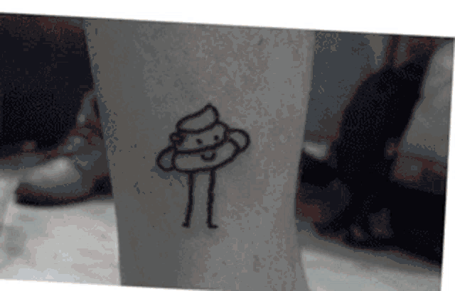 a black and white photo of a person 's leg with a tattoo of a poop .
