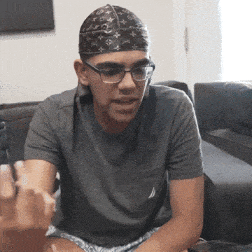 a man wearing glasses and a louis vuitton bandana