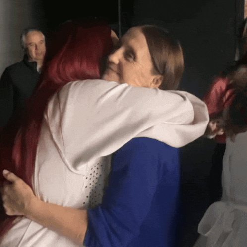 a woman hugging another woman with red hair