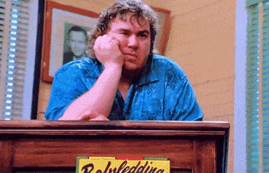 a man sitting at a desk with his hand on his chin and a sign that says ' rowling ' on it