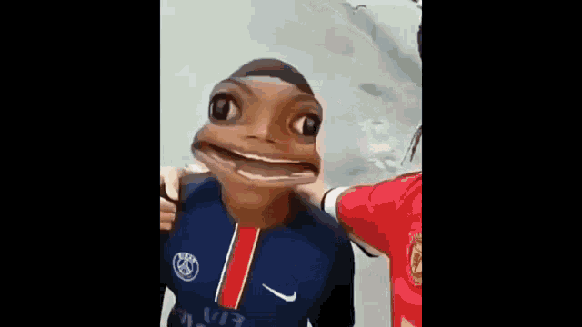 a person wearing a mask with a frog face on it is being held by another person .